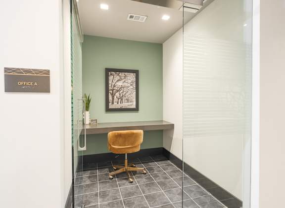 A glass wall separates the office from the hallway.