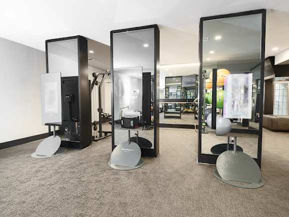 Three mirrors are on stands in a room.
