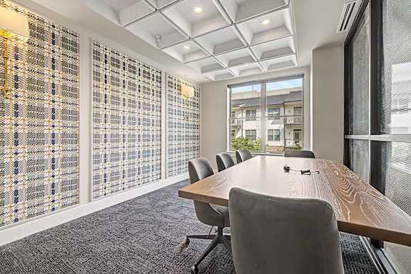 A conference room with a long table and chairs.