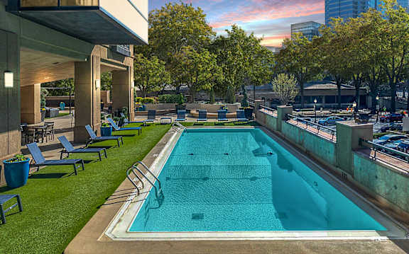 A rectangular pool with a metal railing and a concrete floor.