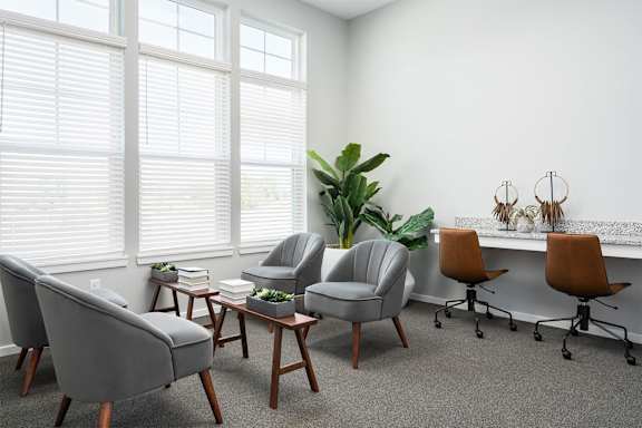 A room with a grey chair and a brown chair.