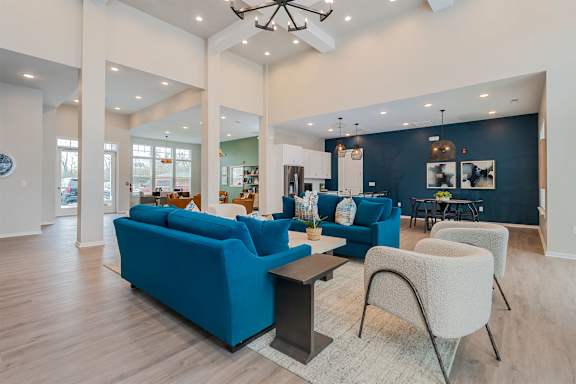 A living room with blue couches and a wooden floor.