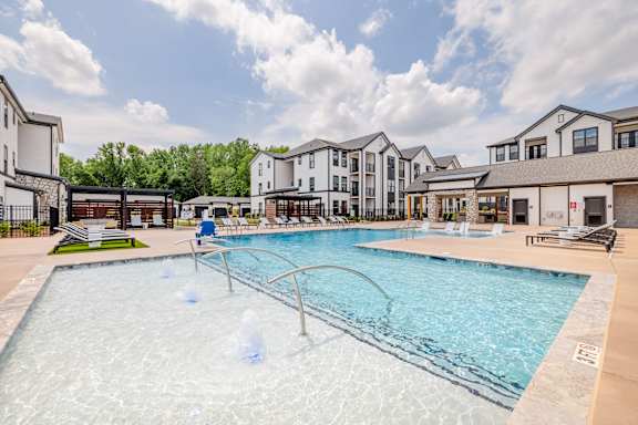 A large swimming pool with a fountain in the middle of it.