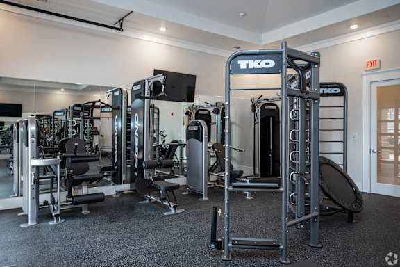 a gym with a variety of exercise equipment and a tv
