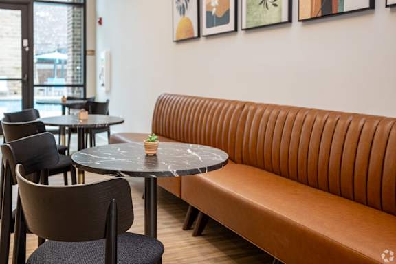 a seating area with a leather couch and tables