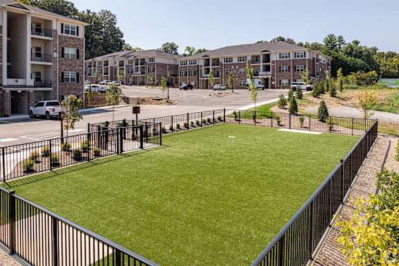 an apartment complex with a green lawn in the middle of the street