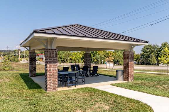 a pavilion with a table and chairs under it