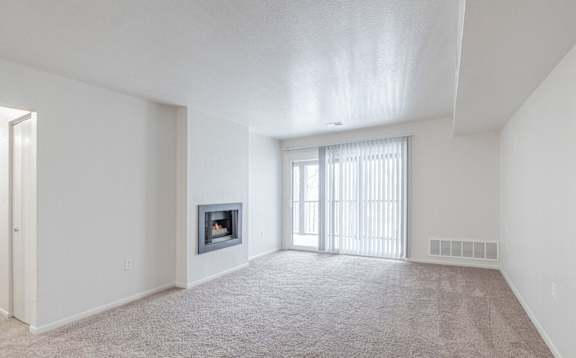 A spacious living room with a fireplace and carpeted floor at Winchell Way Apartment , Kalamazoo, Michigan