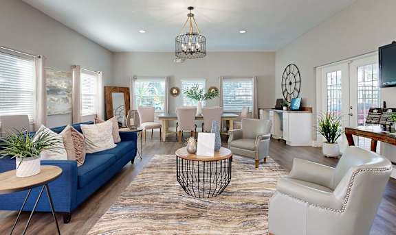 A living room with a blue sofa and white chairs