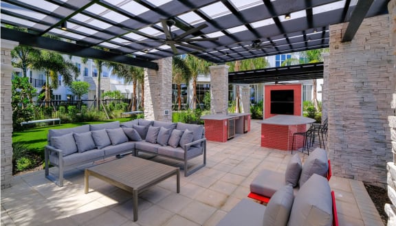 a patio with couches and tables under a pergola at Altis Grand Lake Willis, Orlando, FL 32821