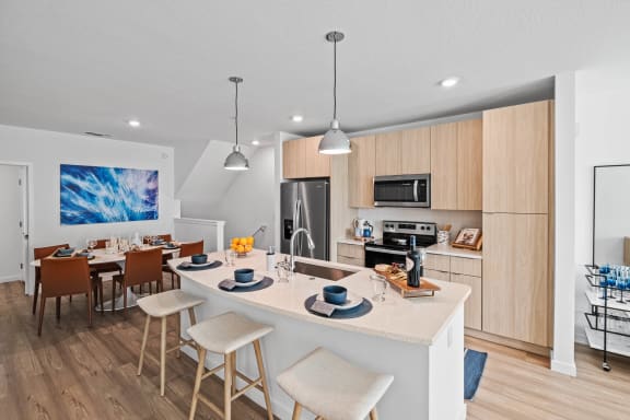an open kitchen and dining area with a white counter top at Altis Grand Suncoast, Land O&#x27; Lakes, FL