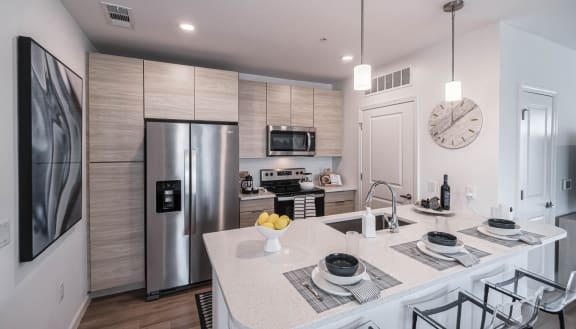 a kitchen with a large island and a stainless steel refrigerator at Altis Grand Lake Willis, Orlando Florida