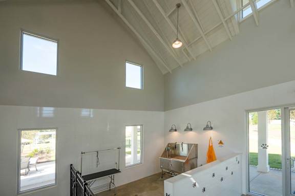 A room with a white ceiling and walls, a window, a table, and a bench.