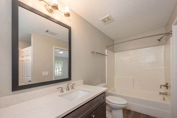 A bathroom with a white sink and a white toilet.