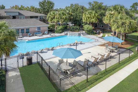 A pool surrounded by chairs and umbrellas.