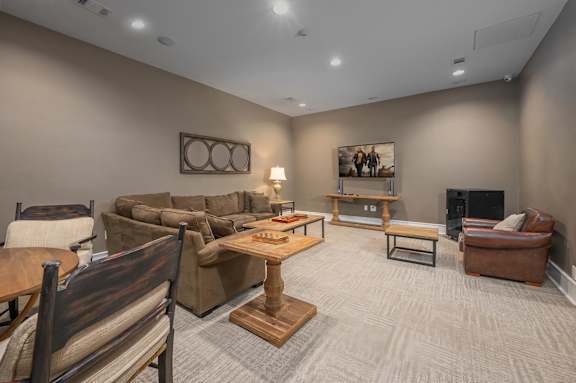 A living room with a brown couch, a wooden table, and a fireplace.