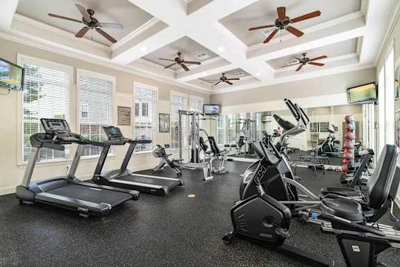 A gym with treadmills, elliptical machines, and other exercise equipment.
