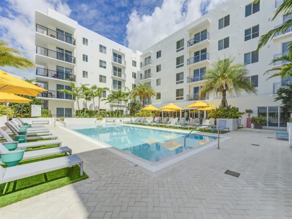 a large swimming pool in front of an apartment building at Altis Little Havana Apartments in Miami, FL 33135