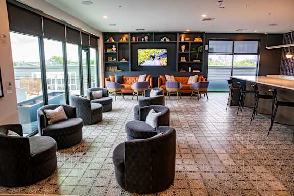 Four chairs are placed on a patio with a city skyline in the background.