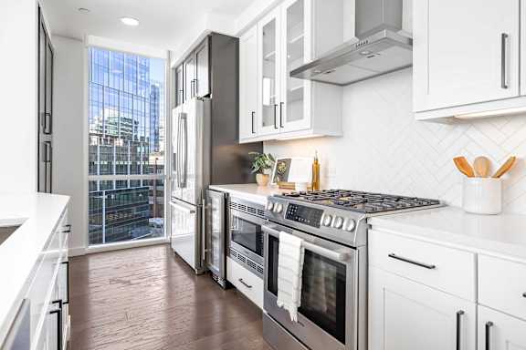 A modern kitchen with stainless steel appliances and white cabinets.