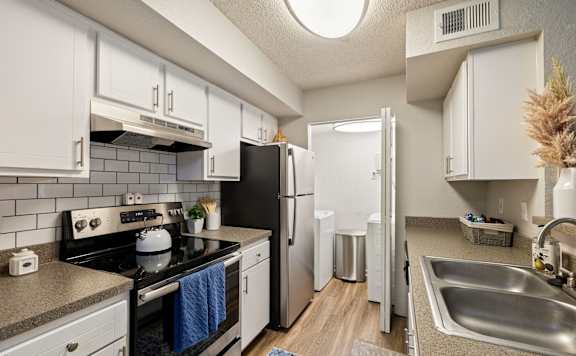 A kitchen with white cabinets and a black stove top oven.