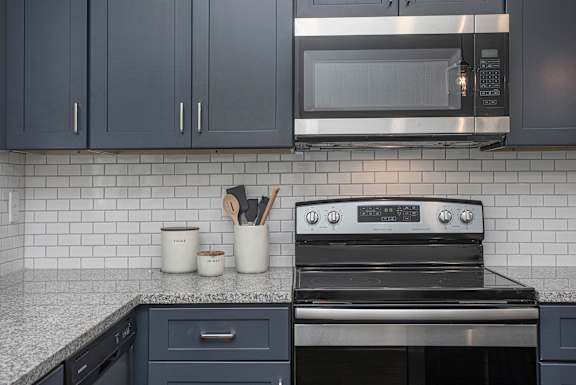 A modern kitchen with a black oven and a microwave above it.