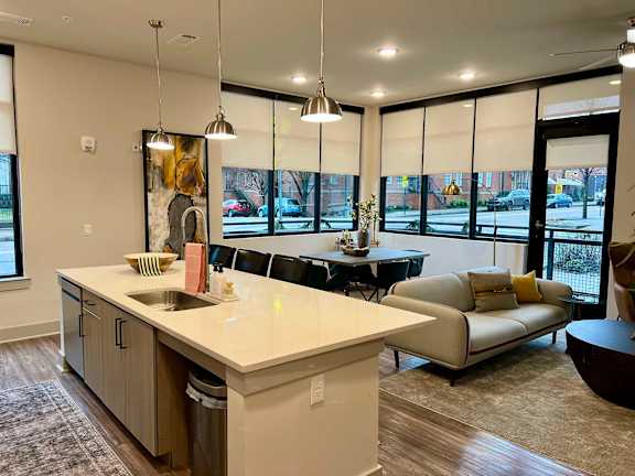 A modern kitchen with a large island and a view of the street outside.