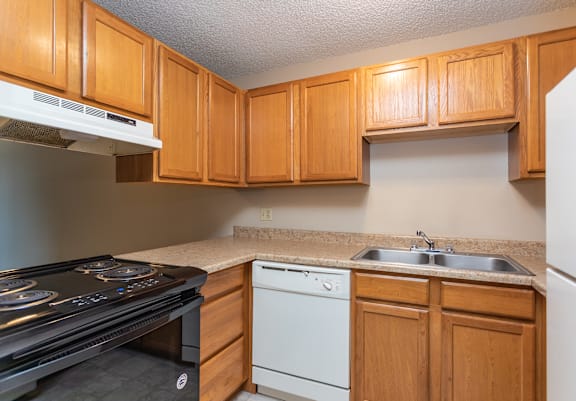 A kitchen with wooden cabinets and a black stove top oven.