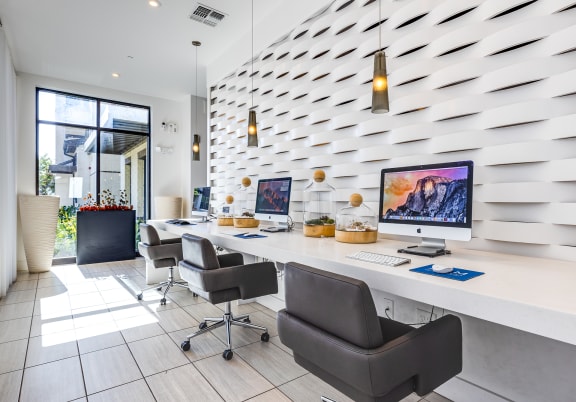 a large office with two desks and two chairs and a wall with a geometric wallpaper