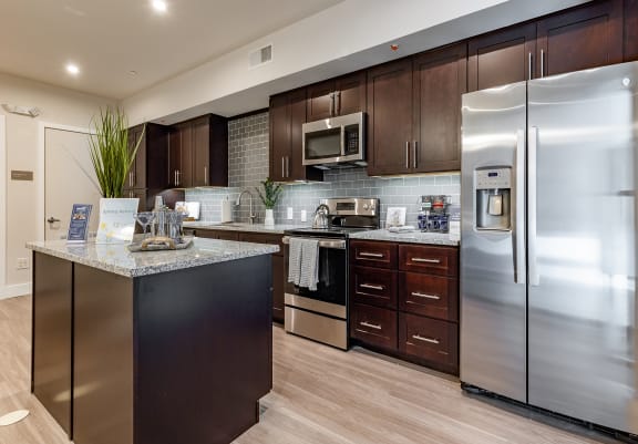 an updated kitchen with stainless steel appliances and granite counter tops