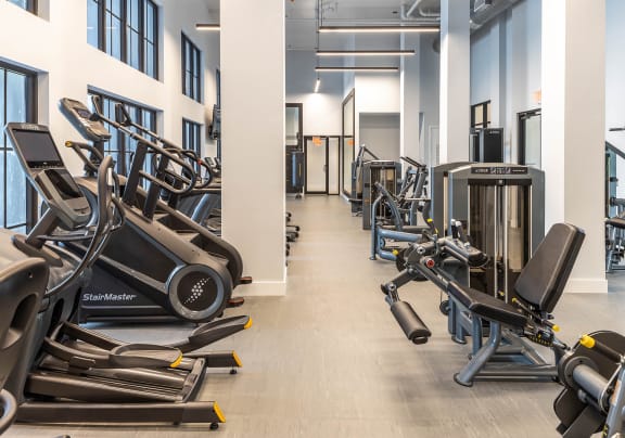 a room filled with cardio equipment and weights at Leena Plantation, Plantation, 33322