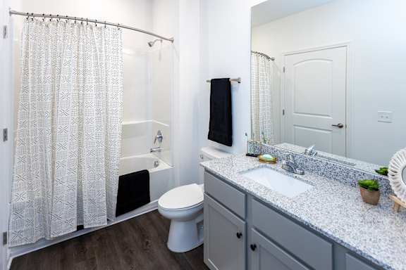 A white bathroom with a toilet, sink, and shower.