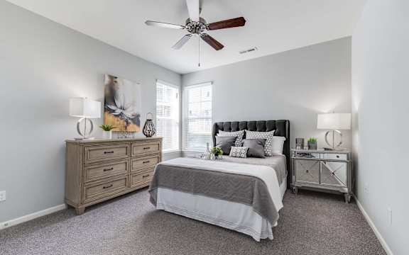 A bedroom with a bed, dresser, and nightstand.