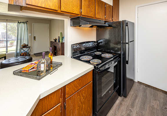 A kitchen with a black stove top oven and a black refrigerator.