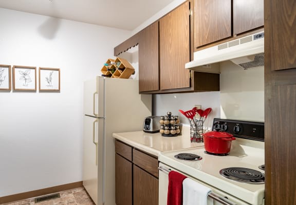 a kitchen with wooden cabinets and a white stove top oven