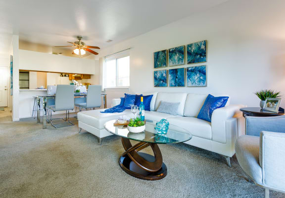 a living room with a white couch and a glass coffee table