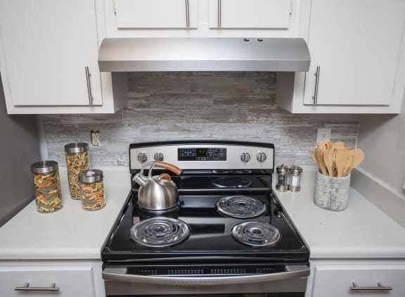 a small kitchen with a stove and a kettle on it
