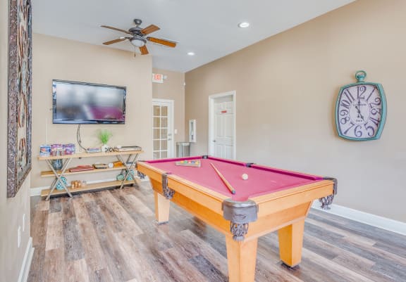 a pool table in a living room with a tv