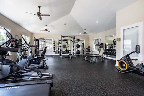 A spacious gym with a variety of equipment including treadmills, elliptical machines, and weights.