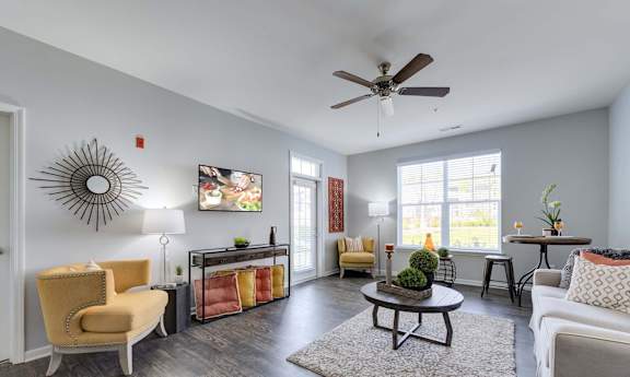 A living room with a yellow chair and a coffee table.