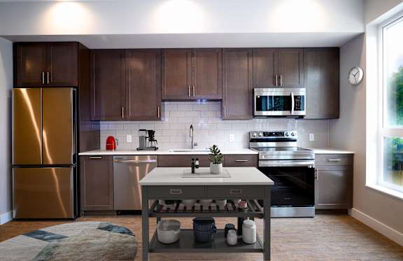 A modern kitchen with stainless steel appliances and wooden cabinets.