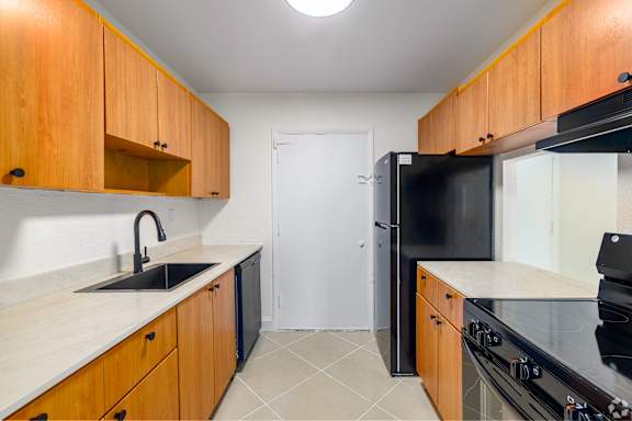 A kitchen with wooden cabinets and black appliances.