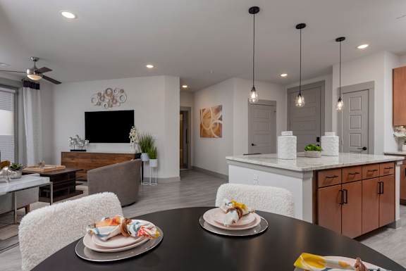 A modern dining room with a black table and white chairs.