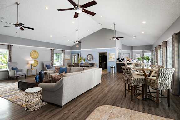 A living room with a white couch and a dining table with chairs at Lake in the Woods, Florida, 32901