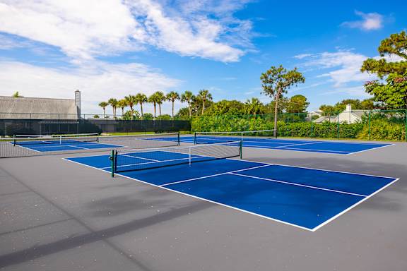 A tennis court with a net and two courts side by side at Lake in the Woods, Florida, 32901