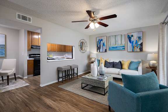 A living room with a blue chair and a white couch at Lake in the Woods, Florida, 32901