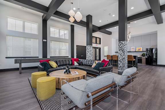 A modern living room with a grey sofa, yellow ottoman, and a coffee table.