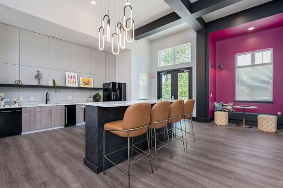 A kitchen with a bar area and chairs.