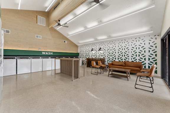 A laundry room with a wash sign on the wall.