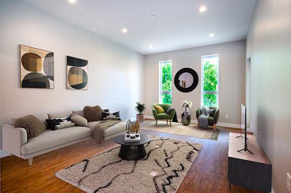 A living room with a white couch, a coffee table, and a rug with a black and white pattern.